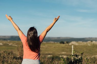 Yürüyüşten sonra kollarını açıp geren İspanyol bir kadının yatay çekimini kapat. Sağlık, spor ve doğa kavramı. Uzayı kopyala Tanımlanamayan kişi