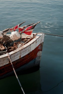 Close-up vertical shot of the bow of an old ship loaded with ropes and maritime items.