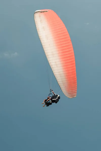 Vertikální Záběr Instruktora Paraglidingu Jeho Studenta Klouzajícího Modré Obloze — Stock fotografie