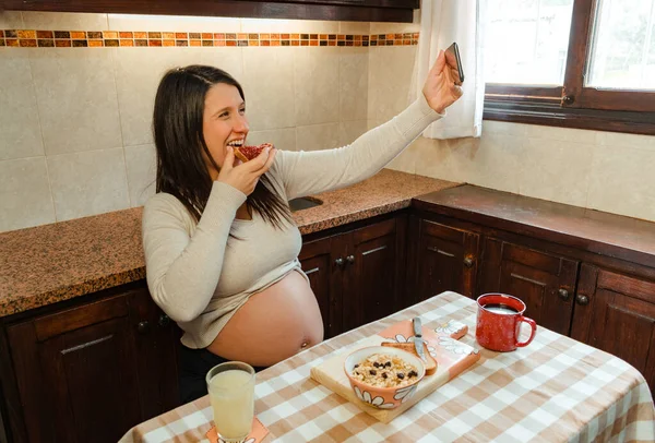 Mujer Latina Embarazada Tomando Foto Mientras Muerde Tostadas Durante Desayuno —  Fotos de Stock