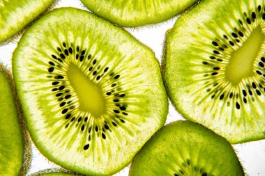 Kivi parlak beyaz bir arkaplanda şeffaf dilimler