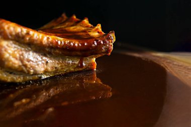 Ahşap tabanda kızarmış domuz kaburgası, tuz, yansıtıcı barbekü sosu ve kopyalama alanı. 