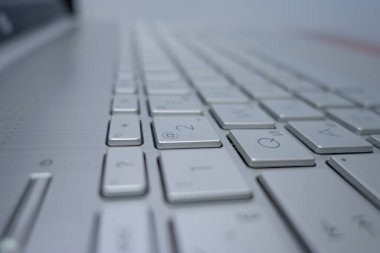 Close-up of a silver aluminum keyboard from a laptop. Side view.
