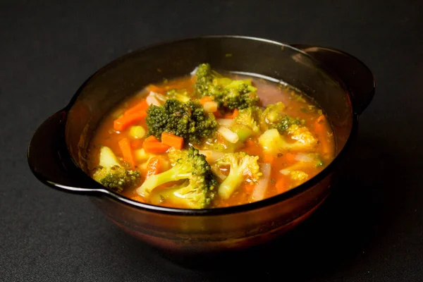 Plate with soup on a black background. Broccoli soup. Delicious food. Background.