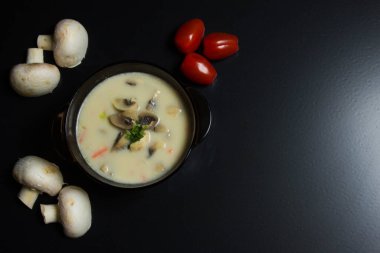 Siyah arka planda çorba tabağı. Mantar çorbası. Arkaplan.