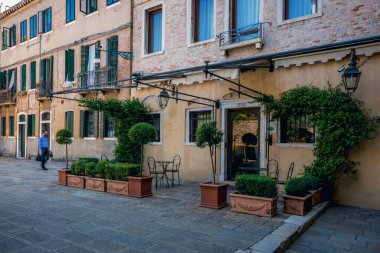 Venedik, İtalya, 07.04.2019. Çiçek ve bitkilerle süslenmiş eski Venedik binasının cephesi..