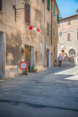 Asciano kasabası, Siena Eyaleti, Tuscany, İtalya: 19 Haziran 2019 - öğle uykusunda tamamen ıssız olan dar sokakların genel görünümü 