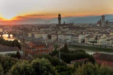 Florence, Italy -20 June, 2019 : panoramic view of the city at sunset, view from Piazzale Michelangelo to river Arno, numerous bridges, and Torre di Arnolfo - 95m-tall medieval tower.
