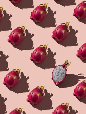 Güzel, taze bir ejderha meyvesi dilimi. Yumuşak pembe arka planda ejderha meyvesi deseni