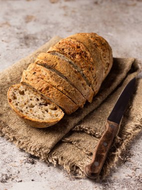 Çuval bezinde dilimlenmiş ekmek. Yanında da bir bıçak var. Arkaplan yapısı