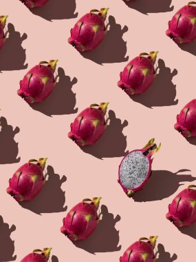 Güzel, taze bir ejderha meyvesi dilimi. Yumuşak pembe arka planda ejderha meyvesi deseni