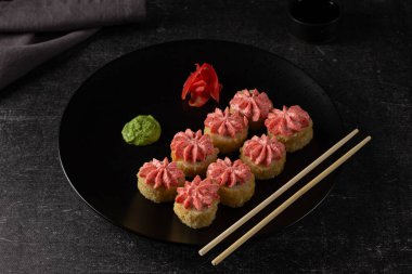 Somonlu suşi, füme yılan balığı, avokado, siyah arka planda krem peynir. Suşi menüsü. Japon yemeği. Gri keten peçete