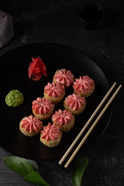 Somonlu suşi, füme yılan balığı, avokado, siyah arka planda krem peynir. Suşi menüsü. Japon yemeği. Gri keten peçete