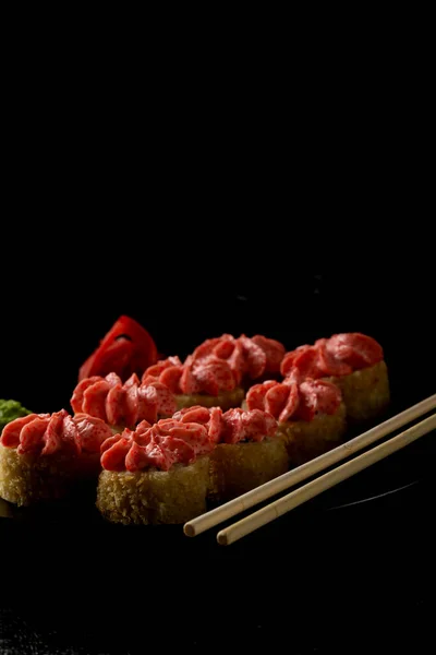 Somonlu suşi, füme yılan balığı, avokado, siyah arka planda krem peynir. Suşi menüsü. Japon yemeği. Gri keten peçete