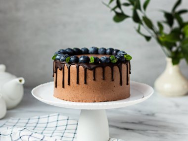 Yaban mersinli çikolatalı pasta. Hafif bir arka planda duruyor. Çikolata lekeleri.