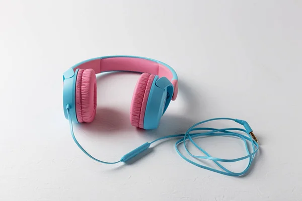 Beyaz arka planda pembe ve mavi kulaklıklar. Çocuklar için kulaklık. Müzik dinle.