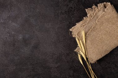 Koyu bir arka planda çuval bezi, üst manzara. Buğday kulakları. Kopyalama alanı