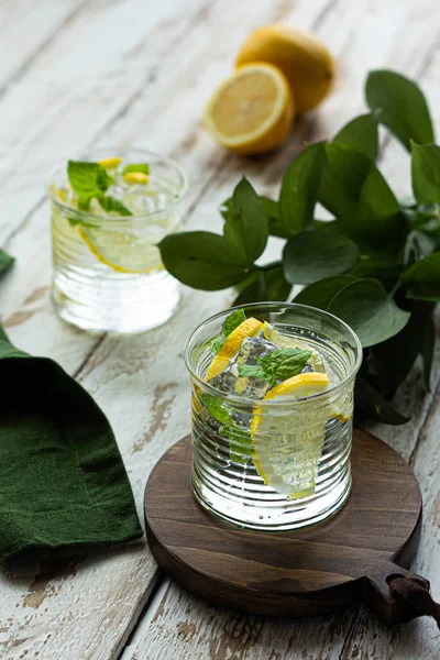 Buzlu ve naneli soğuk limonata. Hafif ahşap bir arka planda. Yaz içkisi fikri.