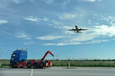 Kopenhag, Danimarka - 8 Haziran 2014. Bir jet inerken Kastrup havaalanı yakınlarında mavi bir kamyon sürüyordu..