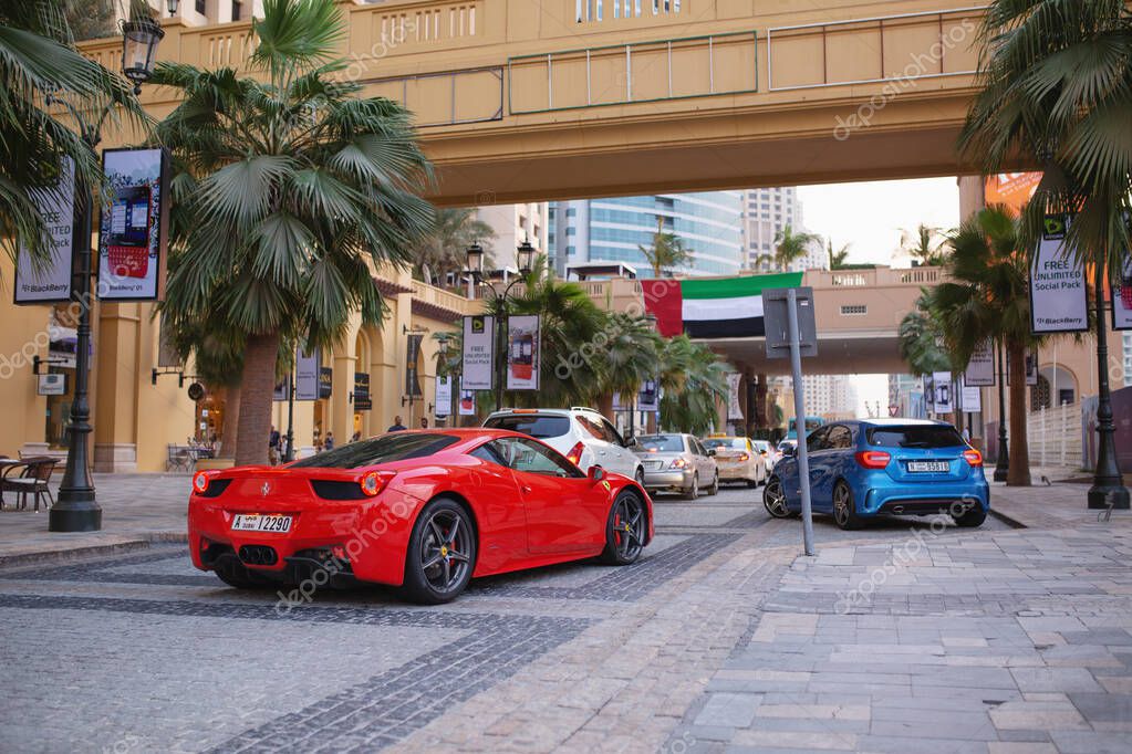 Dubai, UAE - November 20, 2013. Red Ferrari driving in Dubai Maria district.