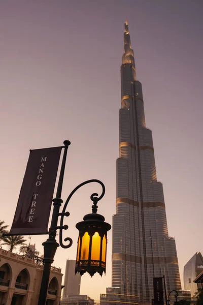 Dubai, BAE - 31 Mayıs 2013. Dubai Alışveriş Merkezi 'nin yanındaki sokak lambasında bulunan Mango Tree Bistro Restoran reklamı ve Dubai' deki Burj Khalifa gökdeleni, Birleşik Arap Emirlikleri.