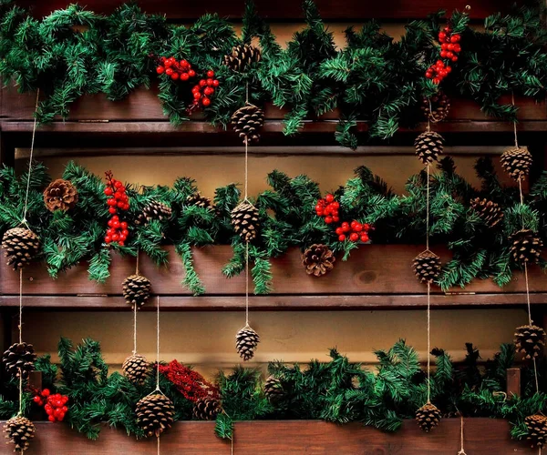 Christmas decor of fir branches and red Rowan berries on a wooden background. The idea of Christmas decoration of the house, garden, cafe and restaurant.