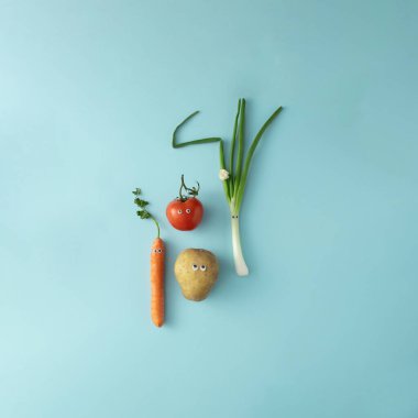 Yumuşak mavi arka planda tatlı gözleri olan taze sebzeler..