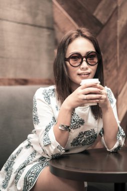 Kahve içme ve kafede gülümseyen Asyalı kadın 