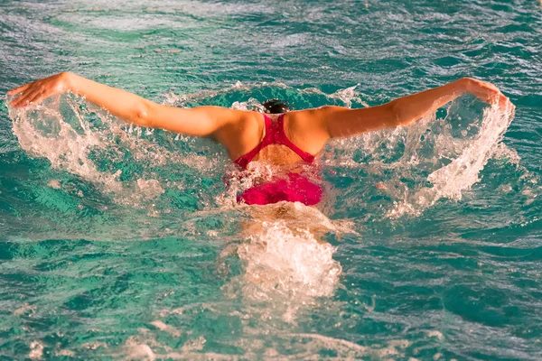 Athlète sur une piscine nageant la technique du papillon . — Photo