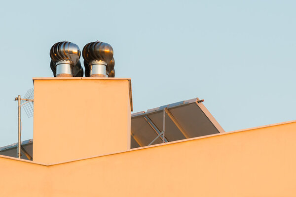 Chimney ventilator fan system on top of a house.