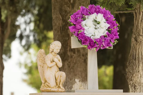 Çiçek çelenk ve bir heykel bir cenaze töreninden sonra mezar taşındaki. — Stok fotoğraf