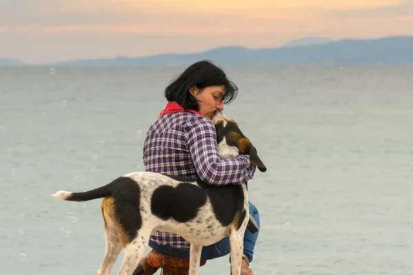 Amor y amistad entre una mujer dueña del perro y su perro contra el mar . — Foto de Stock