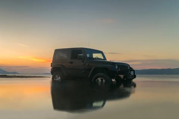 Atina, Yunanistan 1 Temmuz 2016. Jeep 4 x 4 çamur karşı güzel bir gün batımı.