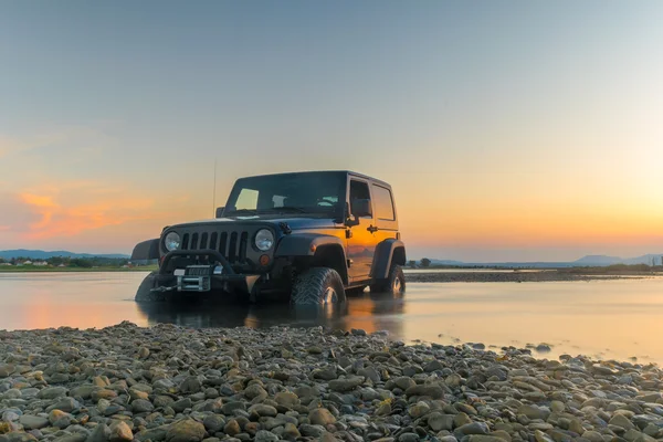 Ateny, Grecja 1 lipca 2016 r. Jeep 4 x 4 przeciwko zachód słońca. Jeep utknął w błocie. — Zdjęcie stockowe