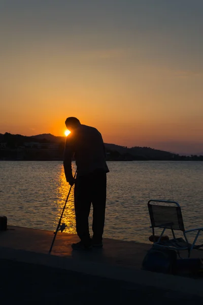 Silhueta de pescador contra o pôr do sol . — Fotografia de Stock