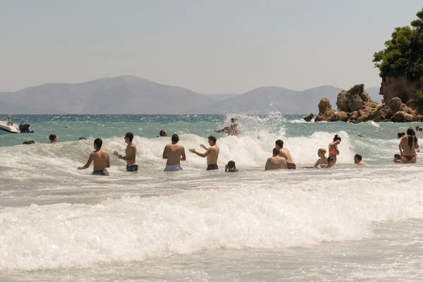 Афины, Греция 19 июля 2015 года. Большие волны на пляже с людьми, играющими и наслаждающимися там свободным временем . — стоковое фото