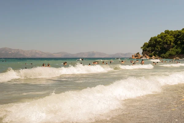 Atina, Yunanistan 19 Temmuz 2015. Bir plajda büyük dalgalar ile oynayanlar. — Stok fotoğraf
