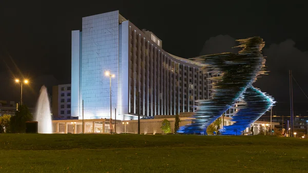 Atina, Yunanistan 25 Kasım 2015. Atina gece koşucu heykeli ve modern bir binada karşı.