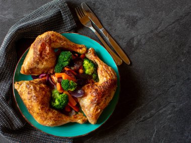 Izgara tavuk budu ve brokoli, havuç ve kırmızı soğan gibi taze pişmiş sebzelerle dolu sağlıklı, düşük karbonhidratlı bir yemek.