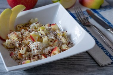 Glütensiz kahvaltı ya da düşük yağlı süzme peynirli aperatif keten tohumu, amamranth pop ve taze doğranmış elmalar yukarıdaki kırsal mutfak masasında servis ediliyor.
