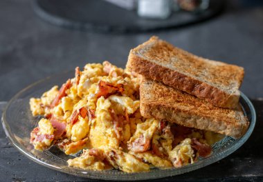 Yağsız jambonlu çırpılmış yumurta ve masada izole edilmiş bir tabakta tost.