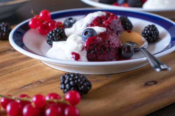 healthy and low fat berry sorbet made with fresh berries and served with a light yogurt sauce on plate with rustic table background