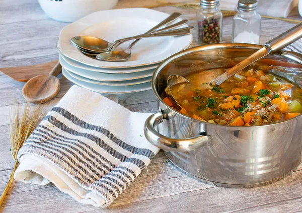 新鲜而自制的胡萝卜炖菜 配以切碎的肉 根蔬菜和土豆 用勺子 盘子和勺子放在乡村木桌的底座上 — 图库照片
