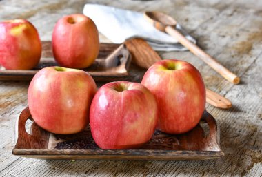 Ahşap masa arkasında pembe elmalar