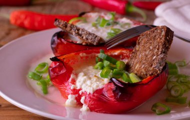 Doldurulmuş biberli yüksek protein yemeği süzme peynirle dolu ve tabakta tam teşekküllü ekmekle servis ediliyor.