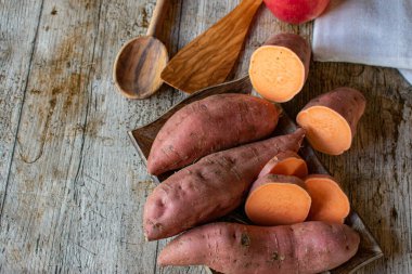 Köy ahşap masa arka planında tatlı patatesler. Kopyalama alanı olan tablo üst görünümü
