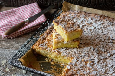 Çörek ve bademli çarşaf keki. Ev yapımı taze bademli kek. Tahta bir masanın üzerinde sıcak servis ediliyor. Çapraz bölüm ve kapatma görünümü