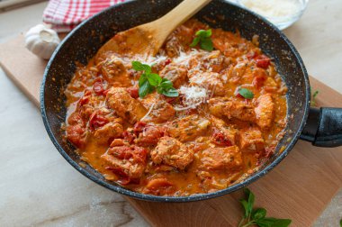 Fried salmon in a delicious tomato cream sauce fresh and homemade cooked in a frying pan