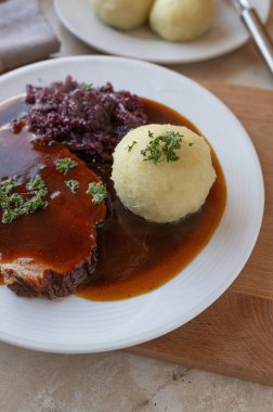 Kırmızı lahana, patates köftesi ve soslu nefis ev yapımı domuz rostosu. Geleneksel Alman yemeği.