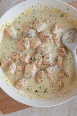 Tavada taze ve ev yapımı dereotu soslu lezzetli küp somon balığı.